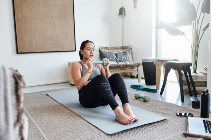 Woman performs weighted sit-up