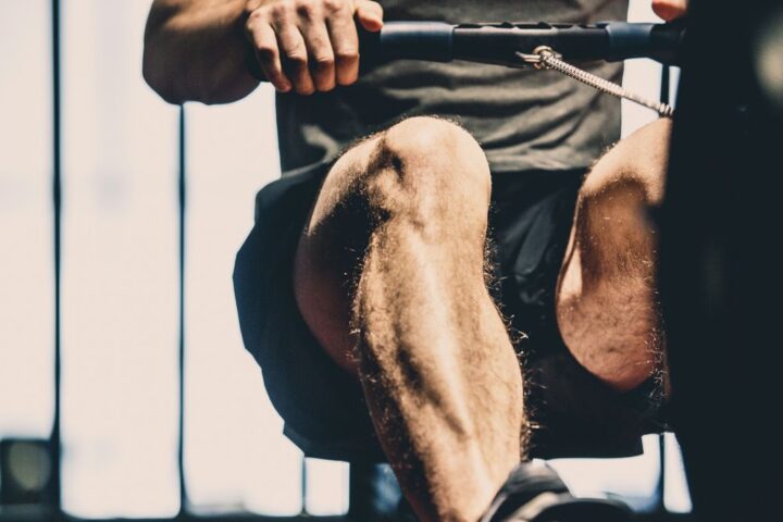 Unrecognisable man using rowing machine